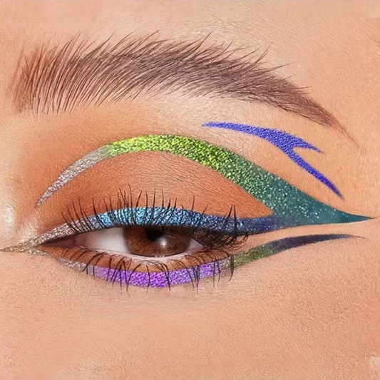 Close-up of an eye with colorful makeup including green, blue, and purple. Duochrome eyeliner graphic liner pen