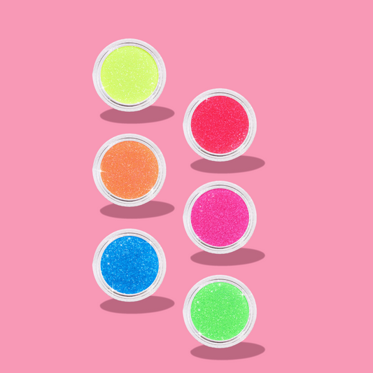 Set of colorful glitter jars on a pink background