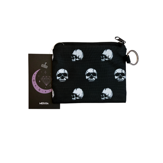 Black pouch with skull patterns and a card with a crescent moon and diamond design on a white background