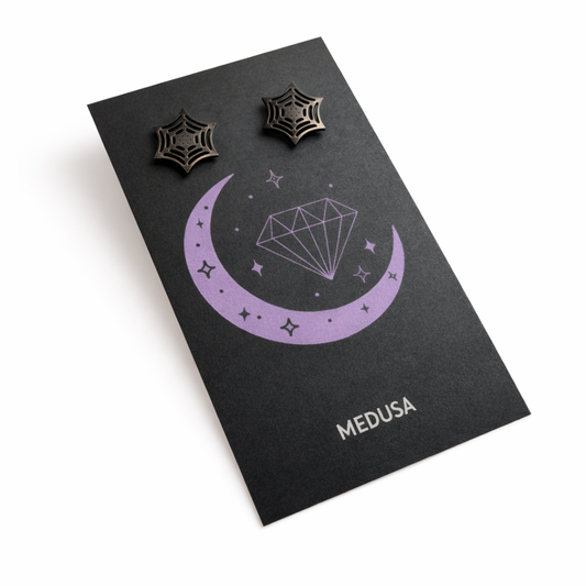 Black card with 'Medusa' branding featuring two spider web earrings on a white background