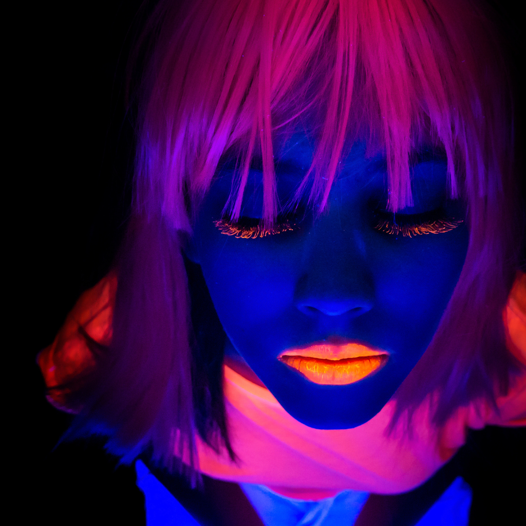 Model wearing neon clothes and neon hair and neon lipstick and neon eyelashes