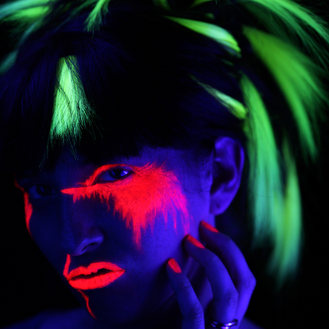 Model wearing neon makeup, neon hair and neon nails, neon lipstick