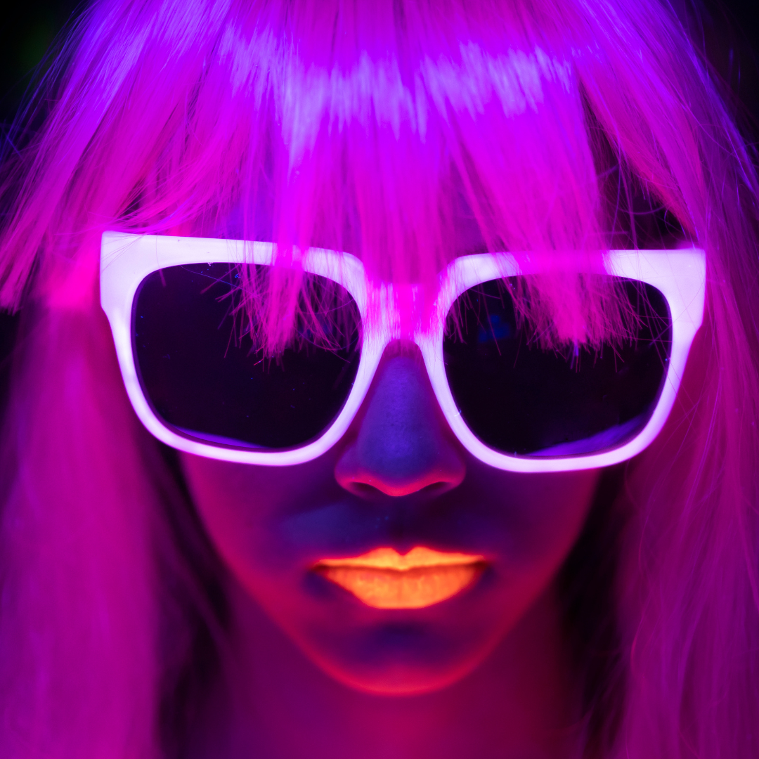 Model wearing neon singlasses with neon orange lipstick
