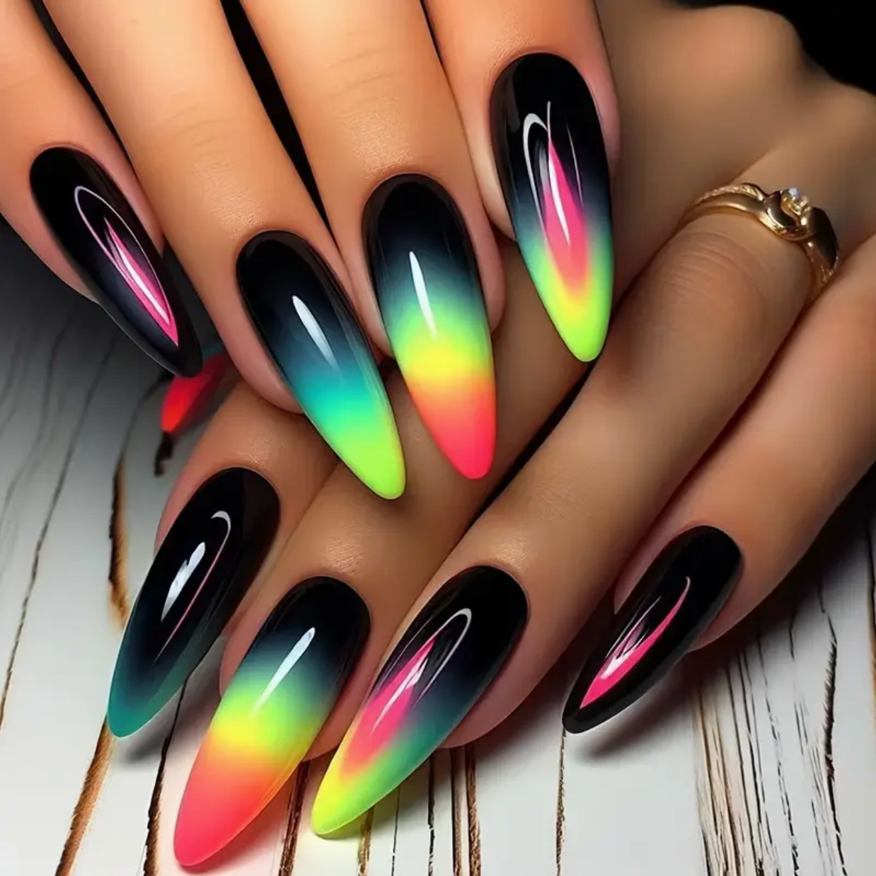 Nails with black, pink, green, and red gradient design on a wooden surface