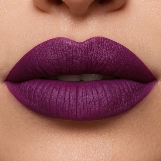 Close-up of a person wearing a vibrant purple lipstick on a neutral background