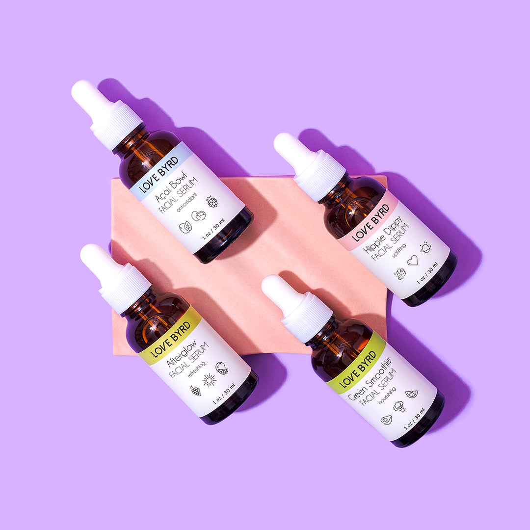 Love Byrd Facial Serum bottles displayed on a pink and purple background