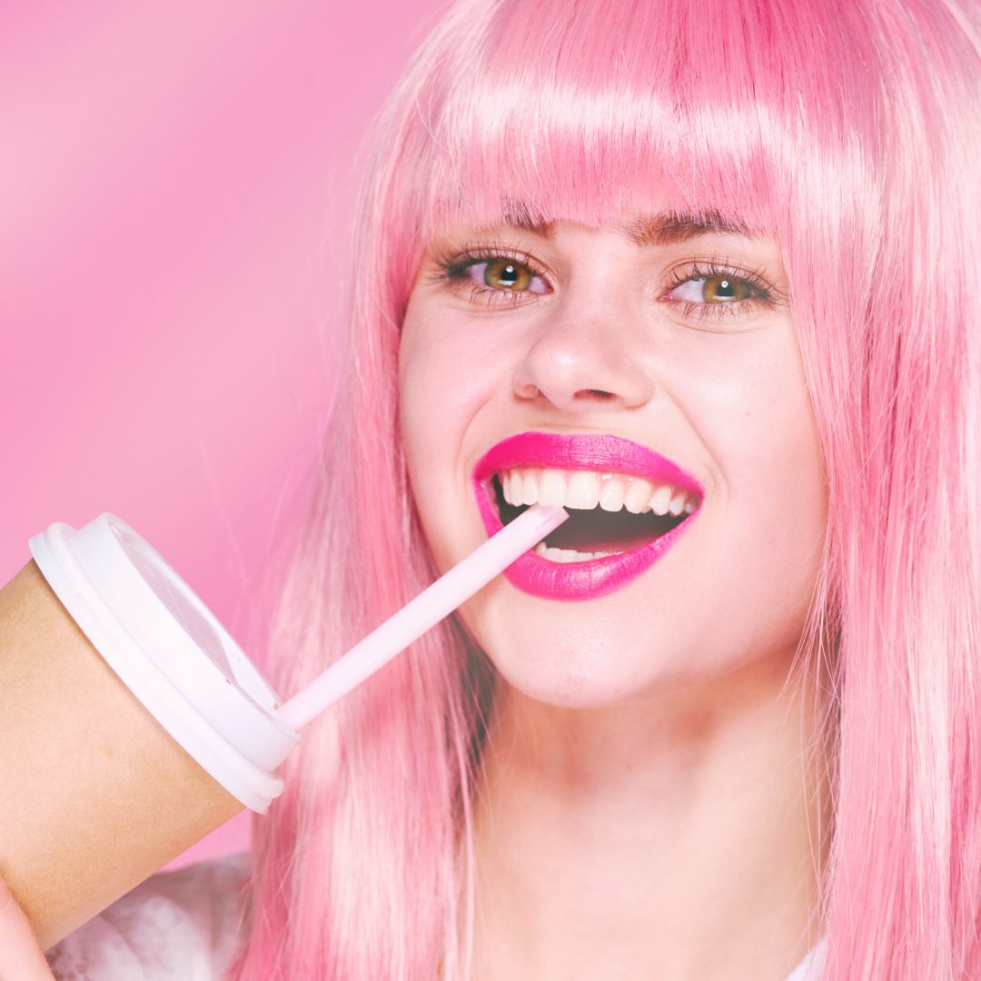 Happily model wear pink hair drinking iced coffee with hot pink lipstick