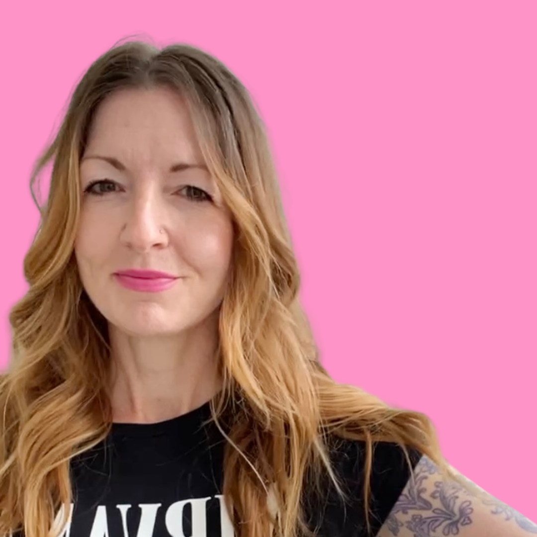 Lora, Boss Babe, CEO. Wearing a Nirvana shirt and against a pink background