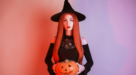 woman with orange hair and witch hat holding a pumpkin