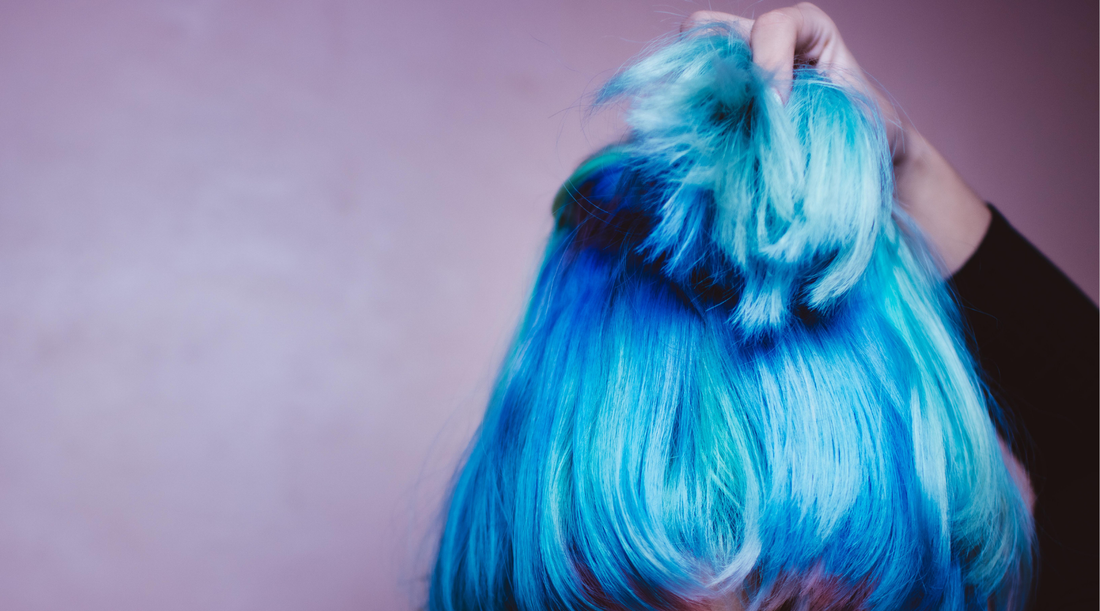 woman with blue hair holding up the top half of her hair