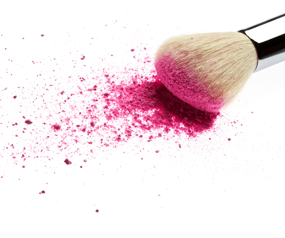 Makeup brush with hot pink blush on it