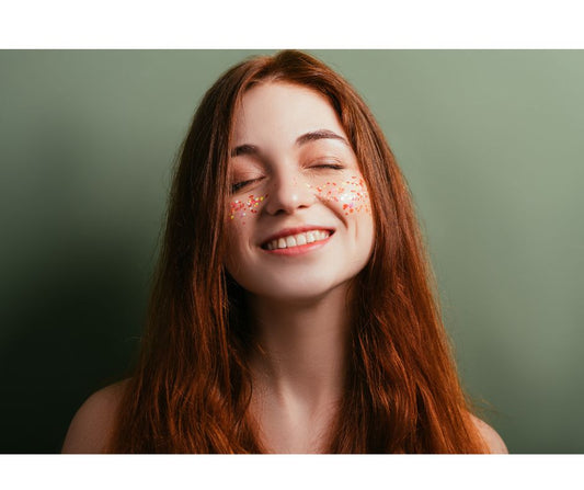 redheaded woman smiling with glitter on her cheeks