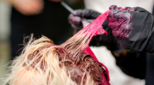 person with gloves dyeing hair pink