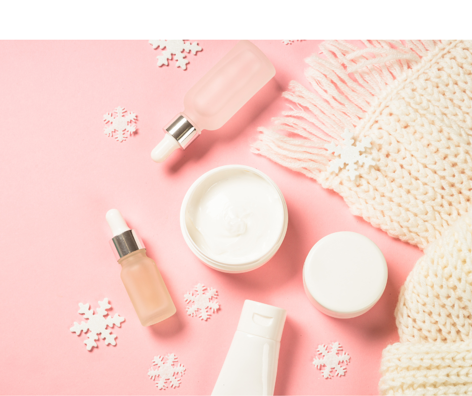 makeup products and snowflakes placed on a pink background
