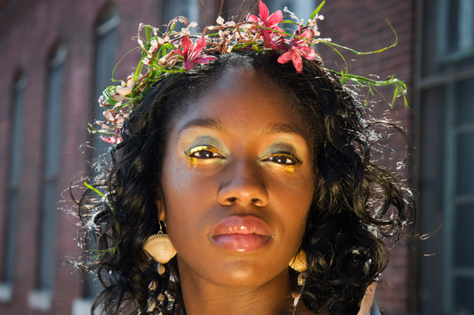 woman with a flower grown and green eyeshadow