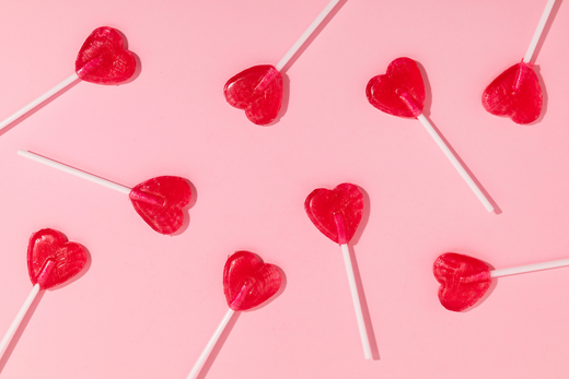 heart shaped lollipops on a pink background