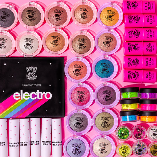 lots of Medusa's Makeup products on a pink background