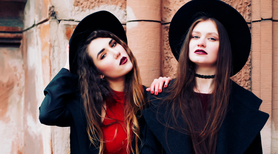 two goth women wearing hats outdoors