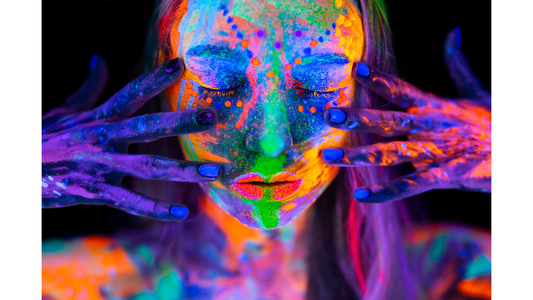 woman with artistic splattered UV Neon Makeup on hands and face