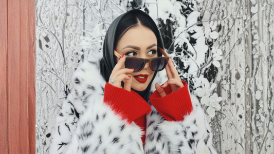 woman in snowy environment with fur coat and sunglasses