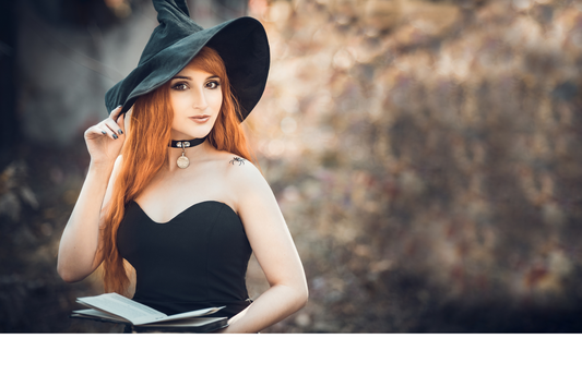 red haired woman wearing  witch hat and holding a book