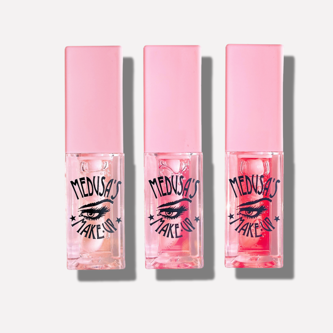 Three pink lip gloss tubes with 'Medusa's Make Up' branding on a white background