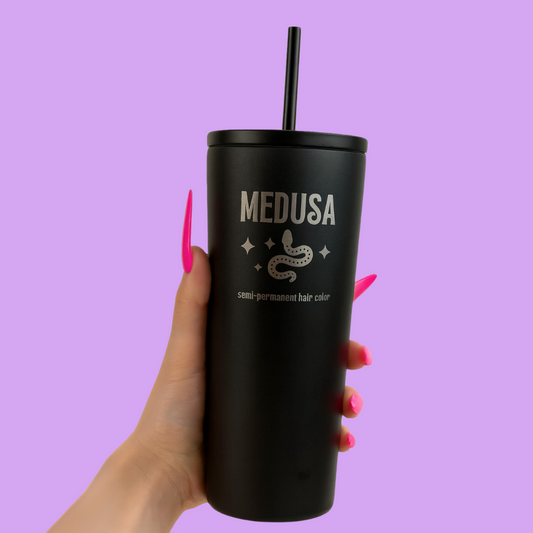Black tumbler with 'MEDUSA' branding held against a purple background