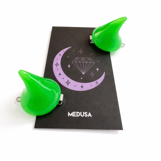 Green devil horns with 'MEDUSA' branding on a black card with a purple crescent moon design.