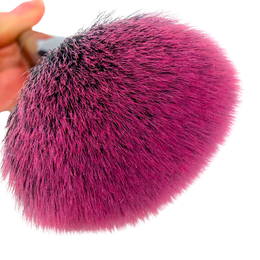 Close-up of a pink makeup brush with a white background
