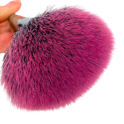 Close-up of a pink makeup brush with a white background