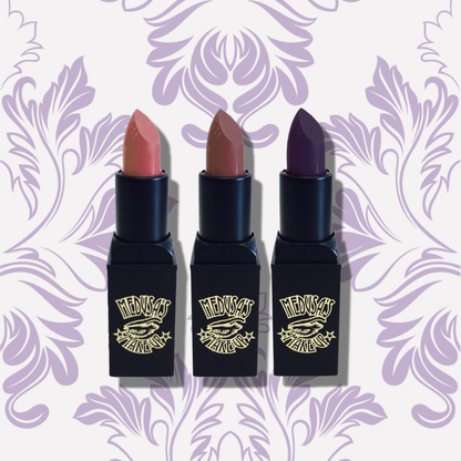 Three lipsticks with different shades on a decorative purple background