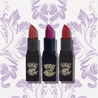 Three lipsticks with black cases on a decorative purple background