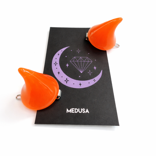 Orange cat ears on a black card with 'Medusa' branding