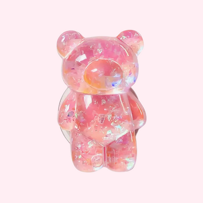 A pink translucent gummy bear-shaped phone pop holder with a shiny, glittery finish.