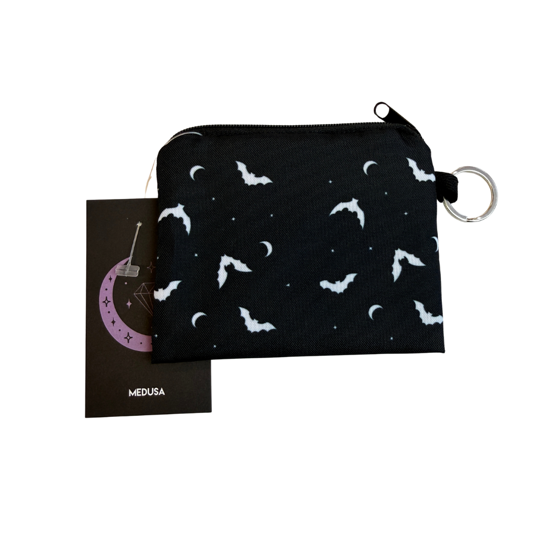 Black pouch with white bat pattern and keychain, with 'MEDUSA' branding on a card.