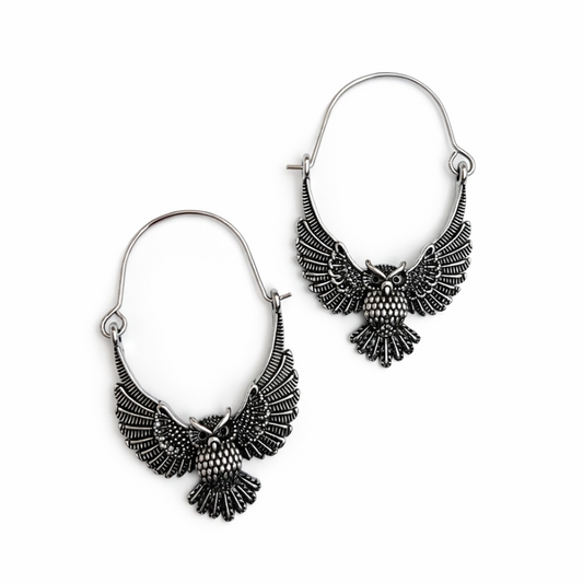 Pair of silver owl-shaped earrings on a white background