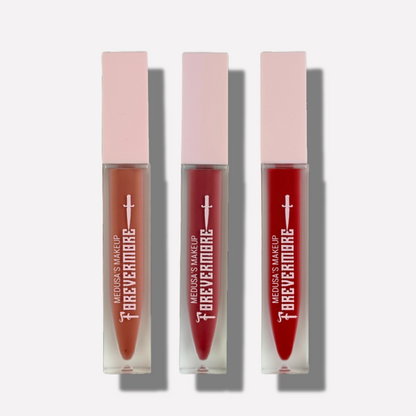 Three lip glosses with pink caps and red shades on a white background