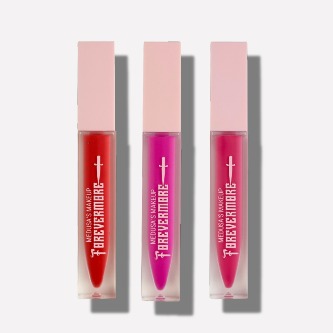 Three lip glosses in red, pink, and purple with 'Forevermore' packaging on a white background.