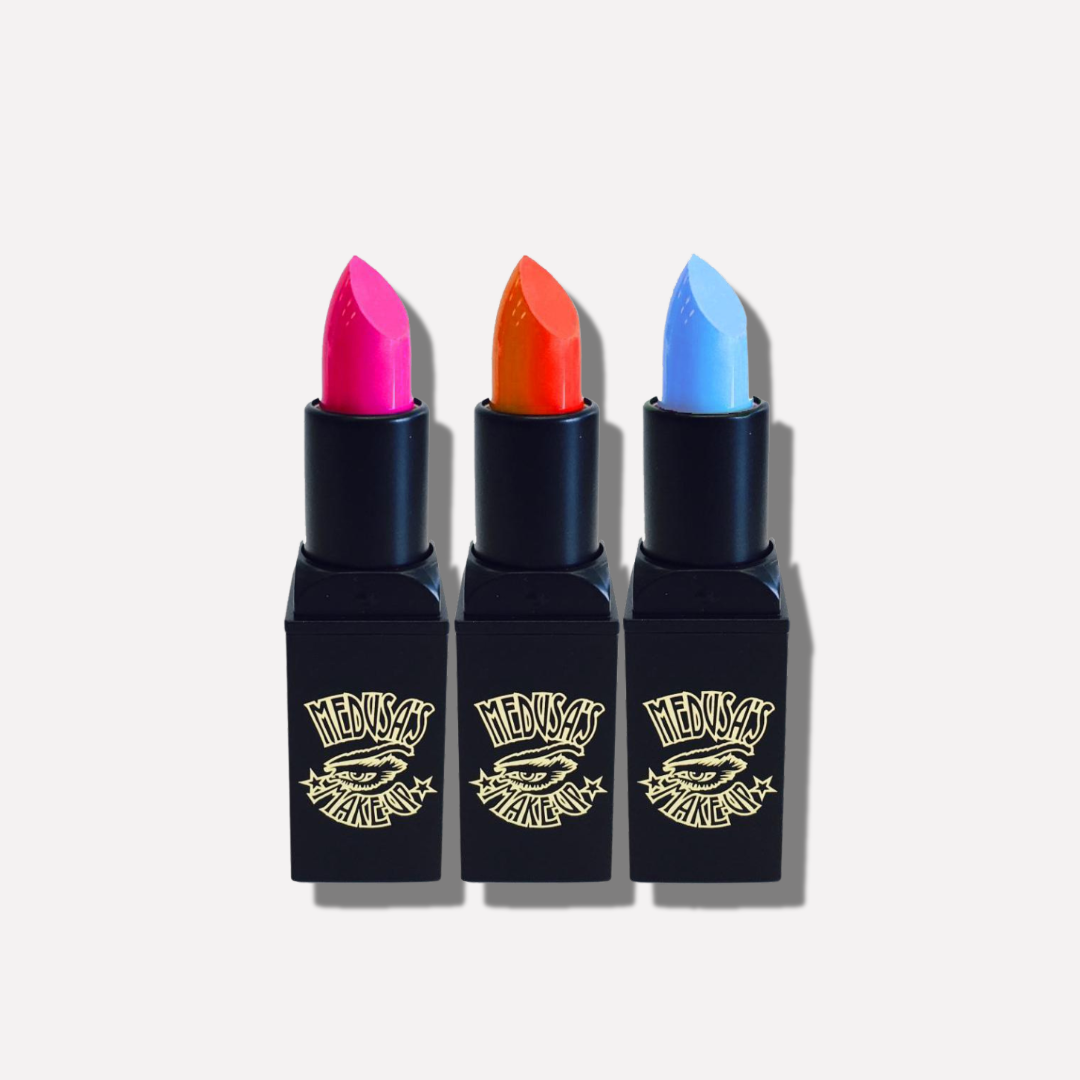 Three lipsticks with colorful caps and black cases on a white background