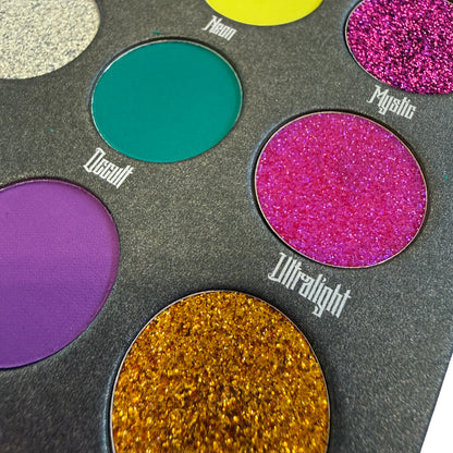 Makeup palette with colorful eyeshadows labeled 'Decadent', 'Mystic', 'Ultralight', and 'Neon'.