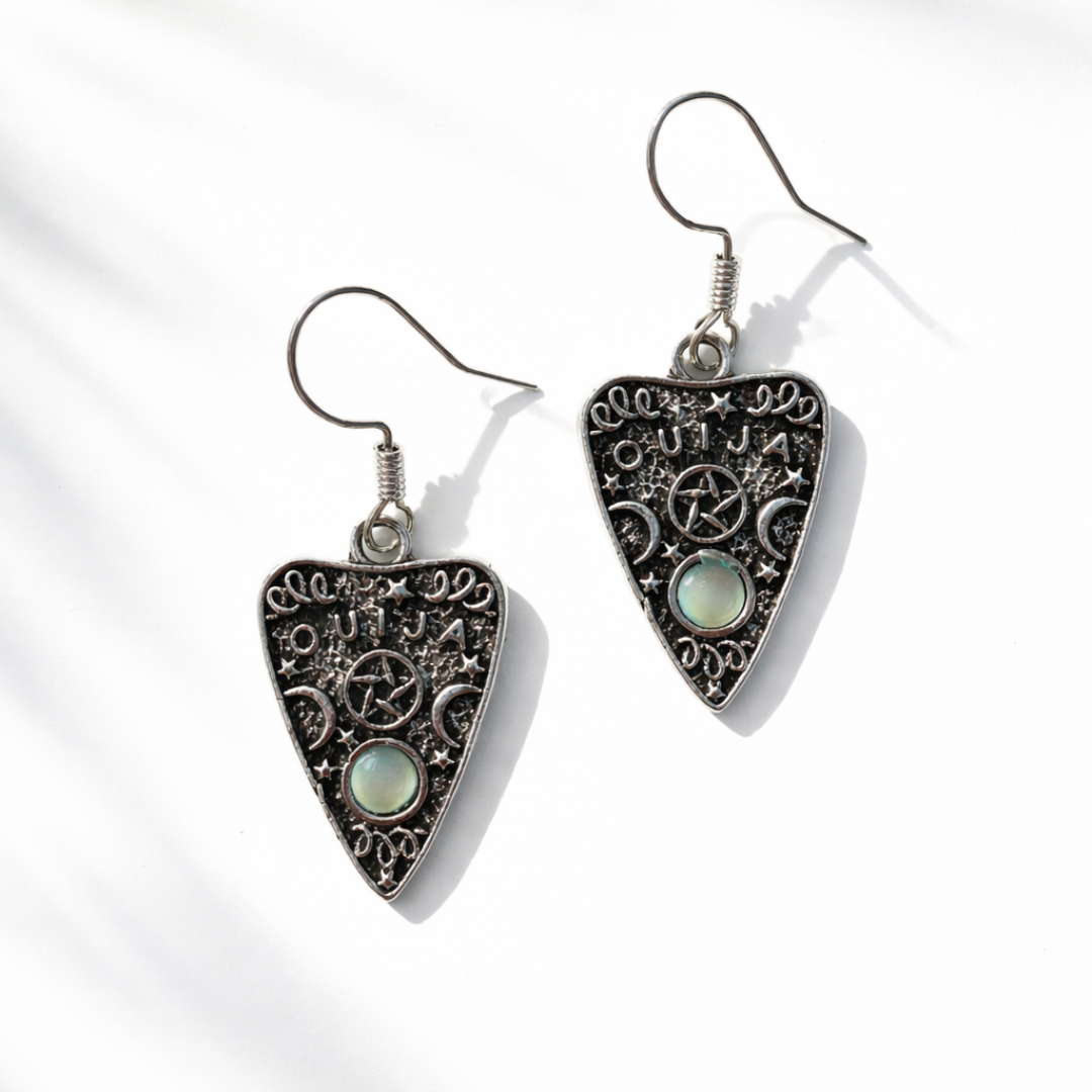 Heart-shaped earrings with intricate designs and gemstones on a white background