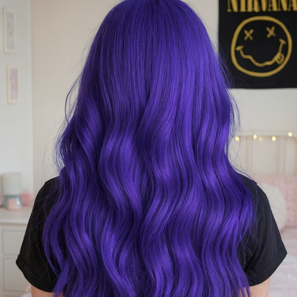 Person with vibrant purple hair in a room with a Nirvana poster on the wall.