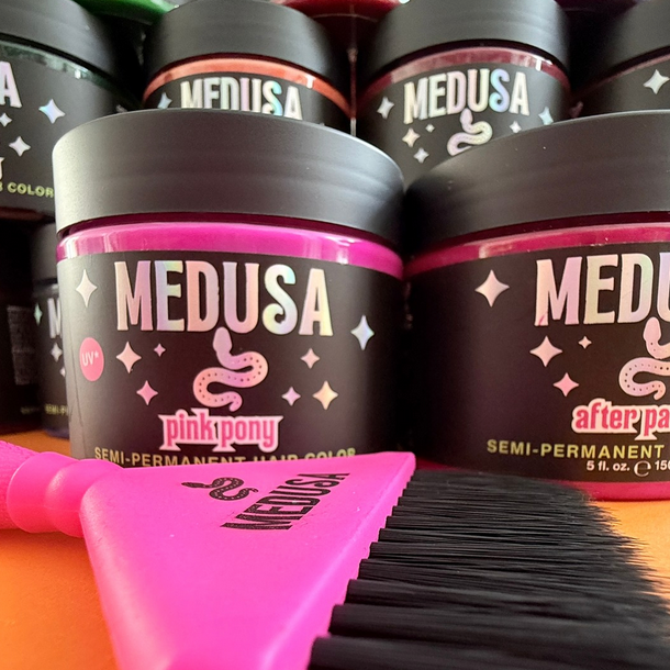Medusa hair color product with a pink comb on a wooden surface