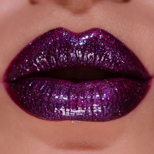 Close-up of glossy purple lipstick on lips
