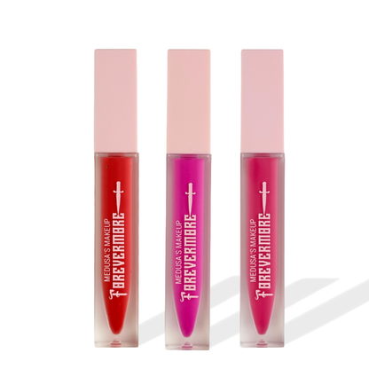 Three lip glosses with pink caps and visible branding on a white background