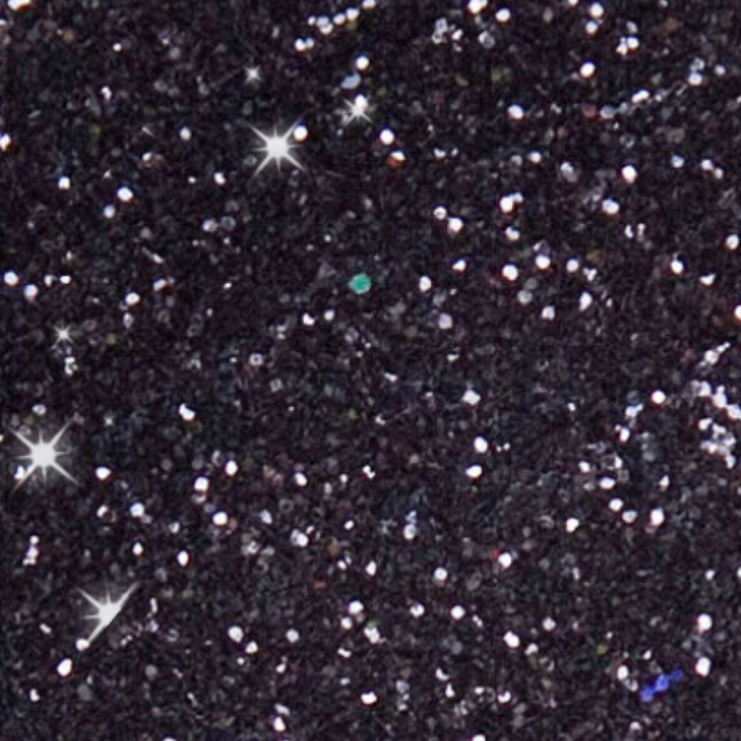 Close-up of a glittery black surface with scattered metallic sparkles.