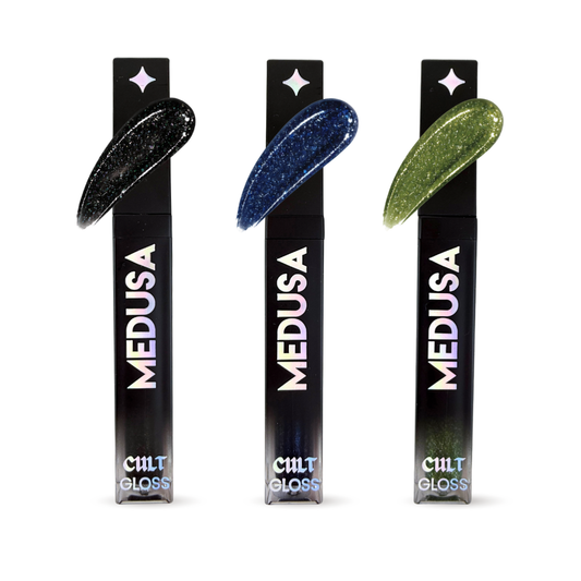 Three bottles of Cult Cosmetics Medusa Gloss with black packaging and colorful applicators on a white background.