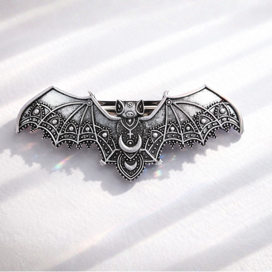 Decorative bat-shaped object with intricate designs on a white background