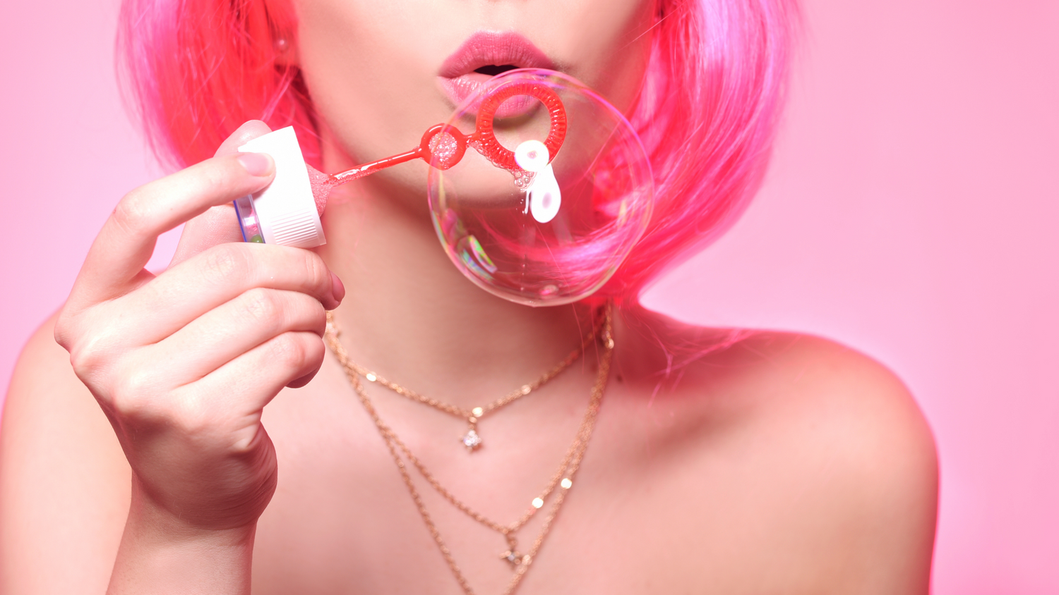 The #1 cruelty free and vegan beauty box. model with pink hair blowing bubbles 