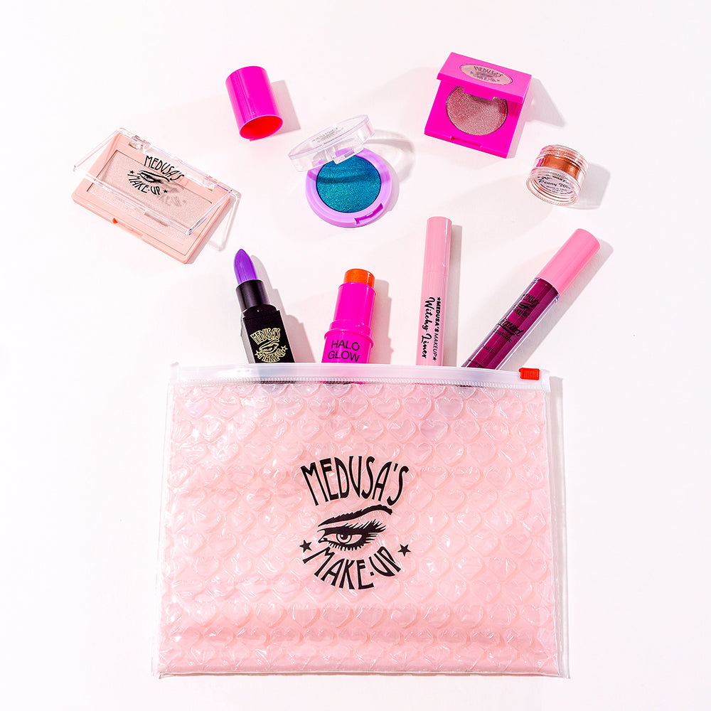 Medusa's Makeup cosmetic bag with makeup displayed around
